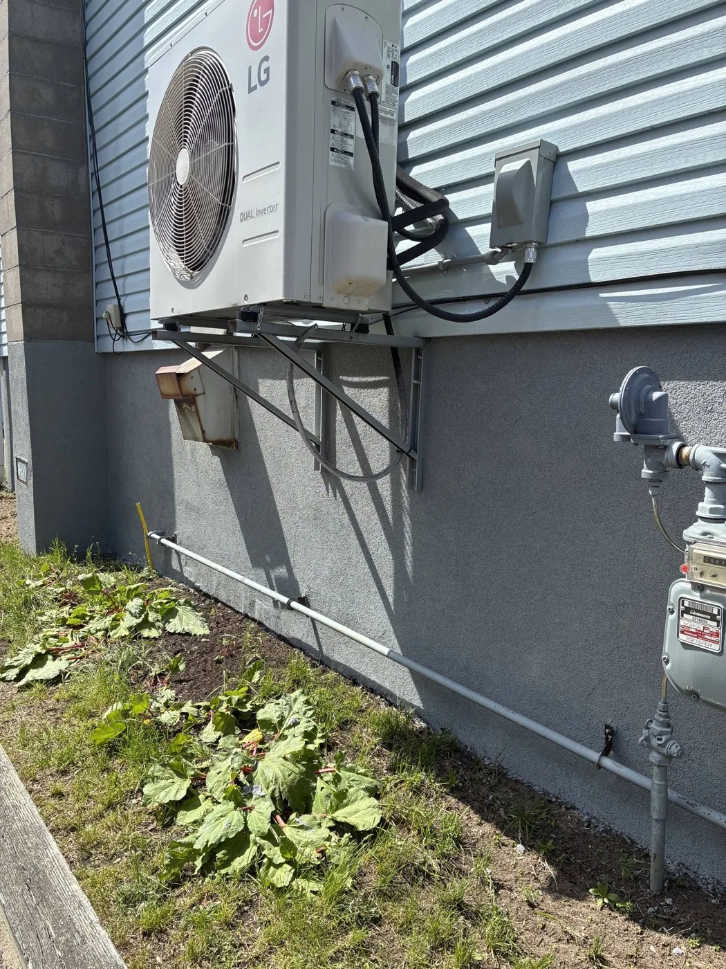 Parged foundation wall finished around a heat pump by Near North Construction and Stucco