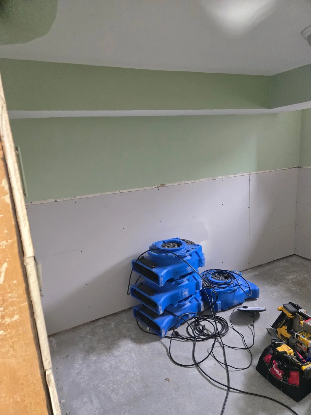 Wet basement dried and prepared for repair with air movers by Near North Construction and Stucco